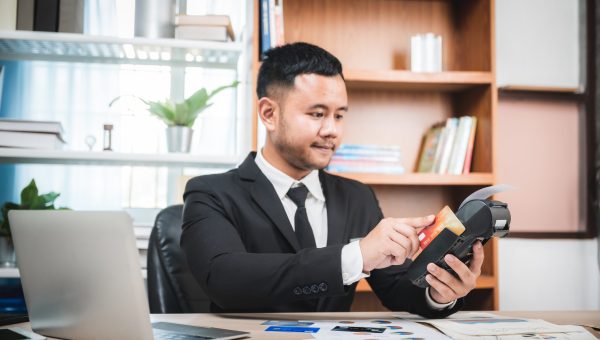 Businessman paying by credit card with a credit card reader machine, e-banking and online business marketing concept