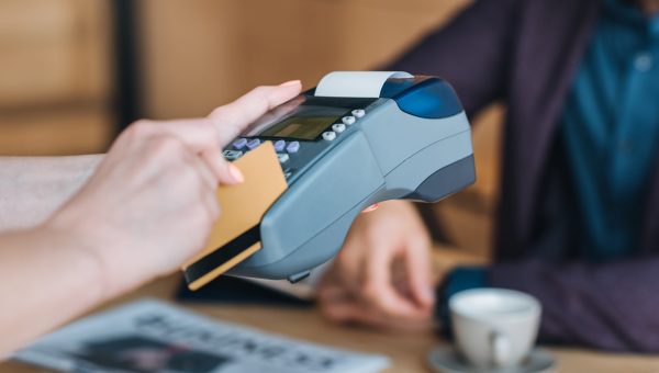 cropped shot of waitress processing payment with credit card and cardkey reader in cafe