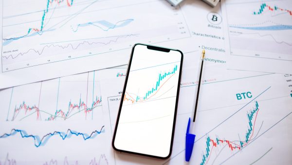 investment stockbroker price trend and profit. Stock market trader analyzing bitcoin price trend. Investment broker trading bitcoin crypto currency using phone and laptop. Multiple devices.